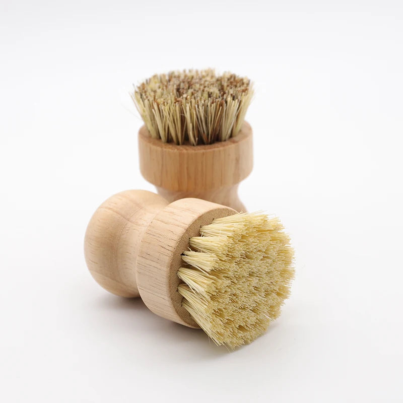 A wooden dish scrub brush with natural sisal bristles is shown on a white background.