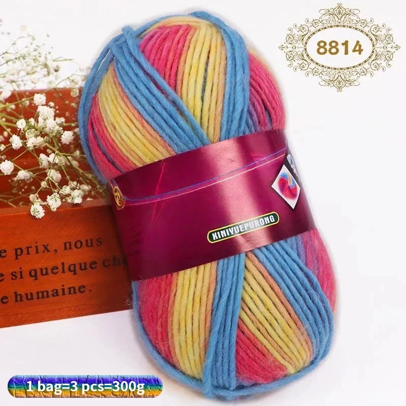 A ball of gradient dyed wool blend yarn featuring pink, yellow, and blue stripes.