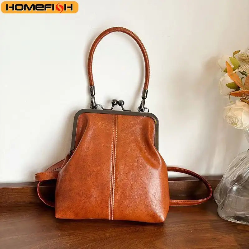 A vintage brown PU leather crossbody handbag with a leather handle is displayed on a wooden surface.