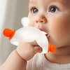 A baby is using a white bunny-shaped silicone teether with orange handles to soothe their gums.