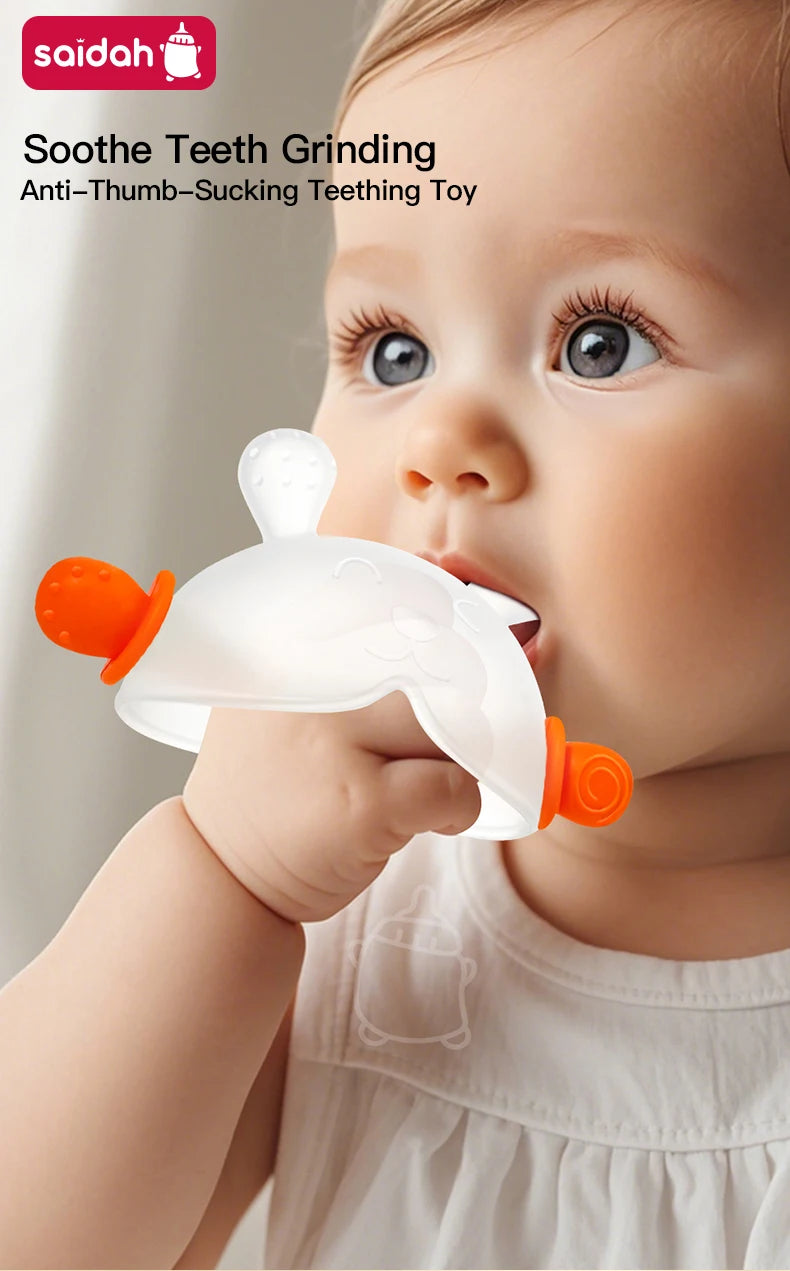 A baby is using a white bunny-shaped silicone teether with orange handles to soothe their gums.