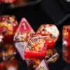 A close-up of a set of translucent red and amber resin dice used for tabletop role-playing games
