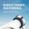 A hand is holding a high-pressure shower head spraying water, demonstrating the filtered shower experience.