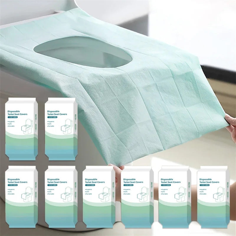 A stack of light mint green disposable toilet seat covers is shown on a surface.