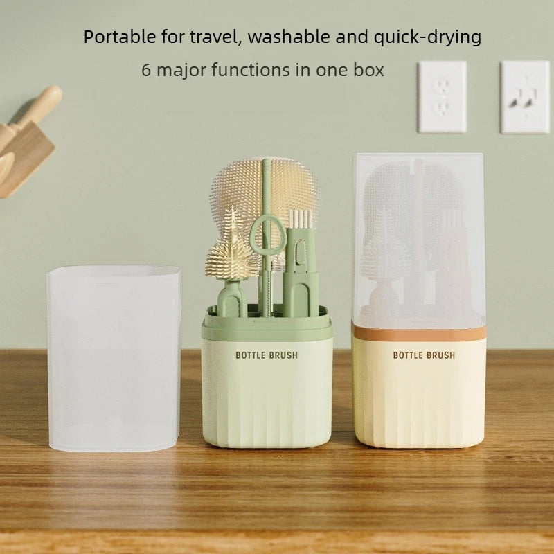 A set of silicone baby bottle brushes in light green and beige are displayed on a wooden surface.
