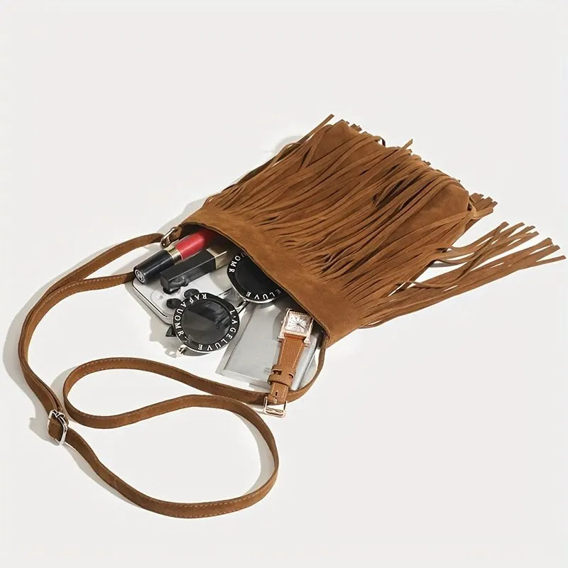 A brown bohemian fringe shoulder bag with leather straps and accessories.