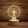 A glowing wireframe light sculpture of a Ferris wheel mounted on a base.
