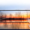 Eine Hand berührt ein transparentes Auto-DVR-Display, das eine Sonnenuntergangsansicht durch die Linse zeigt.
