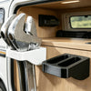 A wall-mounted organizer rack holding two silver wrenches inside a wooden vehicle compartment.