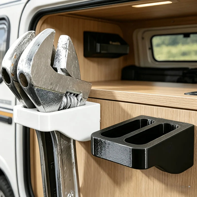 A wall-mounted organizer rack holding two silver wrenches inside a wooden vehicle compartment.