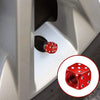 Close-up view of aluminum alloy dice design tire valve caps being installed on a vehicle wheel.