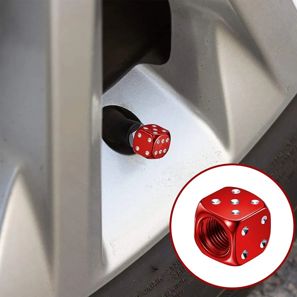 Close-up view of aluminum alloy dice design tire valve caps being installed on a vehicle wheel.