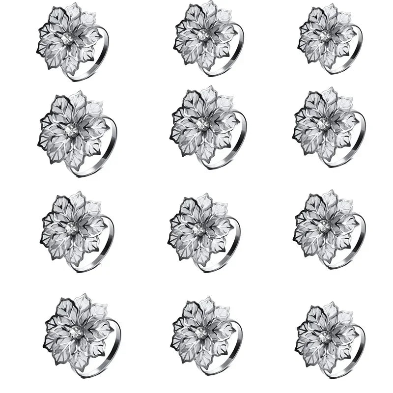 A set of twelve decorative metal napkin rings featuring a hollow-out floral pattern.