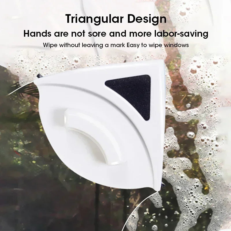 A white triangular magnetic window cleaner device is shown cleaning a window surface.