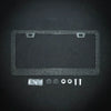 A clear crystal rhinestone license plate frame with screw caps and mounting hardware displayed on a dark surface.