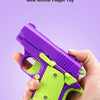 A hand holds a purple and lime green mini pistol fidget toy for stress relief.