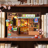 A display of a vintage Japanese corner shop diorama kit featuring books and merchandise, set on a wooden shelf.