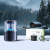 A black smart car diffuser with ambient blue light is shown on a white surface in a snowy forest landscape.