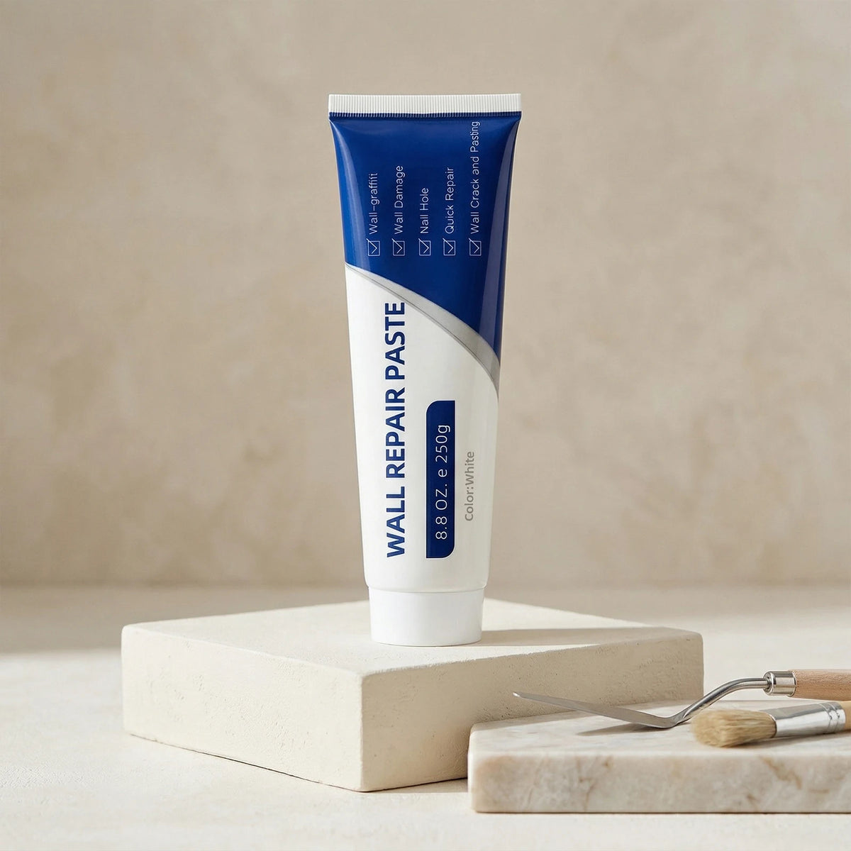 A tube of Wall Repair Paste is shown standing on a light wooden block with a small brush and scraper nearby.