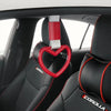 Red heart-shaped car handle decor with a holographic strap hanging from the interior of a car seat.