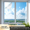 A window with a light-colored film installed, showing a bright blue sky and distant cityscape.