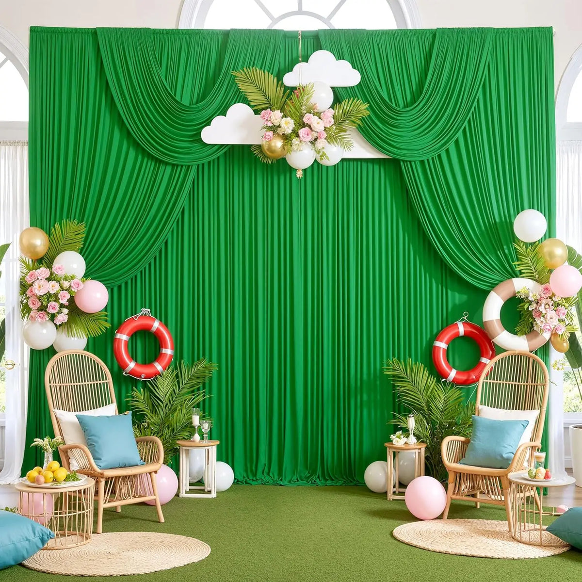 Üppige grüne Stoffkulisse mit weißen Wolken, rosa Blumen und goldenen Akzenten in einem hellen Raum.