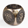 A bronze metal spinner dice cube featuring embossed dragon designs and a triquetra symbol.