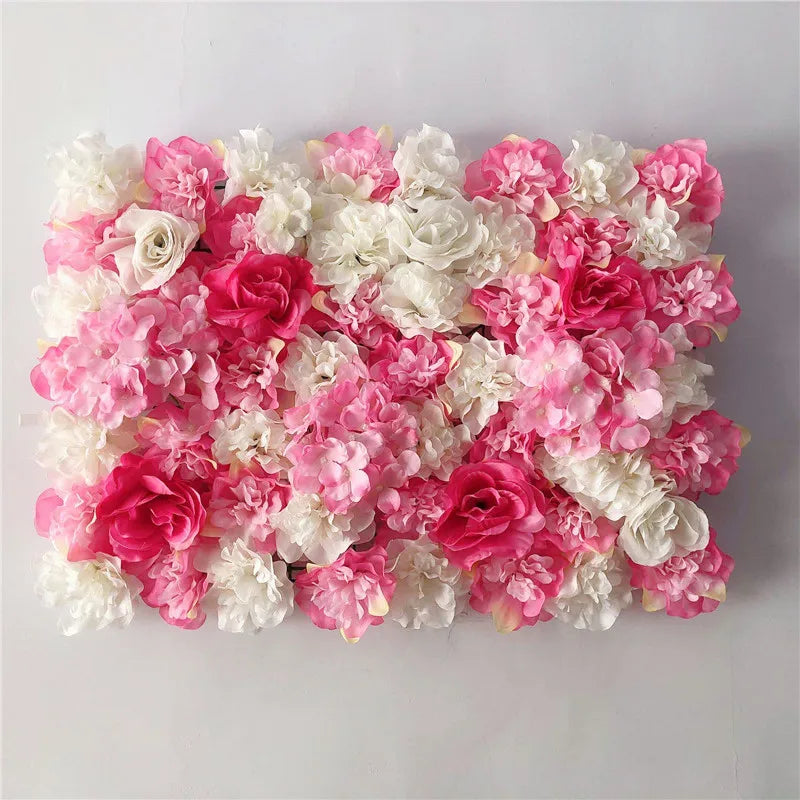 A dense wall panel of pink and white silk rose flowers for weddings and events.
