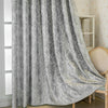 Gray tree bark jacquard blackout curtain panel draped next to a light wood chair.
