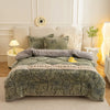 A green plush throw blanket with floral embroidery is displayed on a bed, surrounded by white and cream bedding.