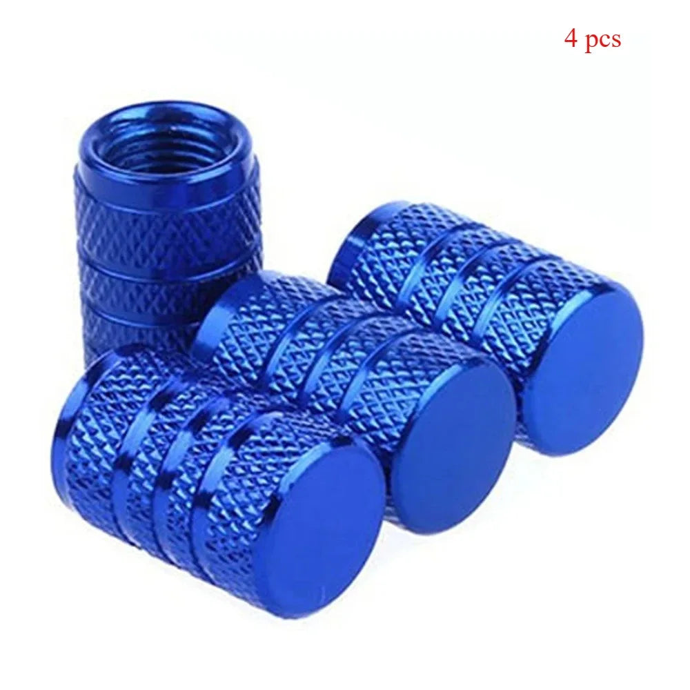 A set of four blue knurled aluminum tire valve caps.