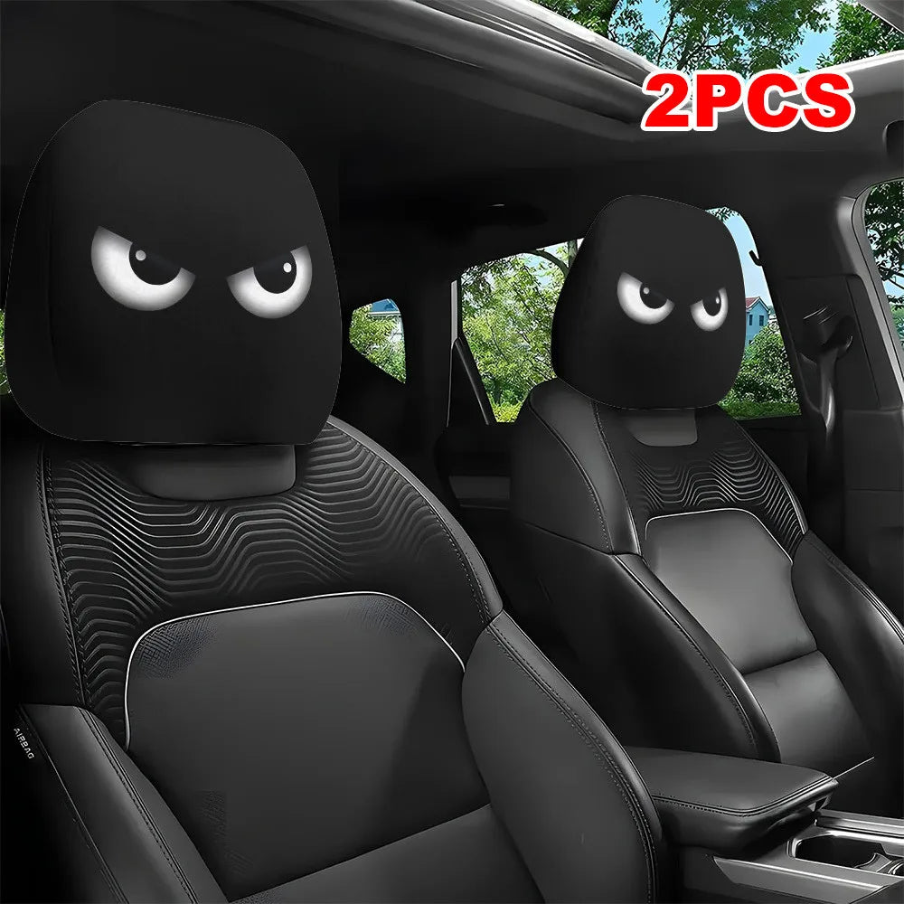A pair of black car headrest covers with slanted eyes are shown inside a vehicle interior.