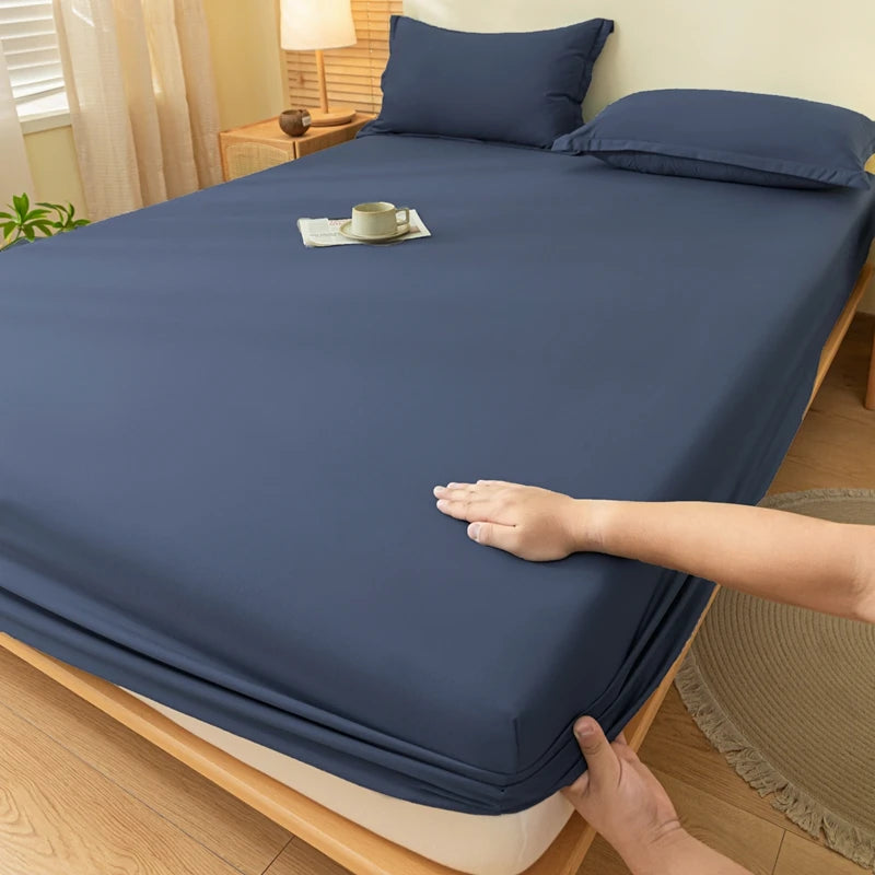 A dark blue fitted sheet is draped over a bed, showing its soft texture and elastic edge.