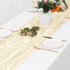 A white table setting featuring a beige semi-sheer gauze table runner, plates, silverware, and floral arrangement.