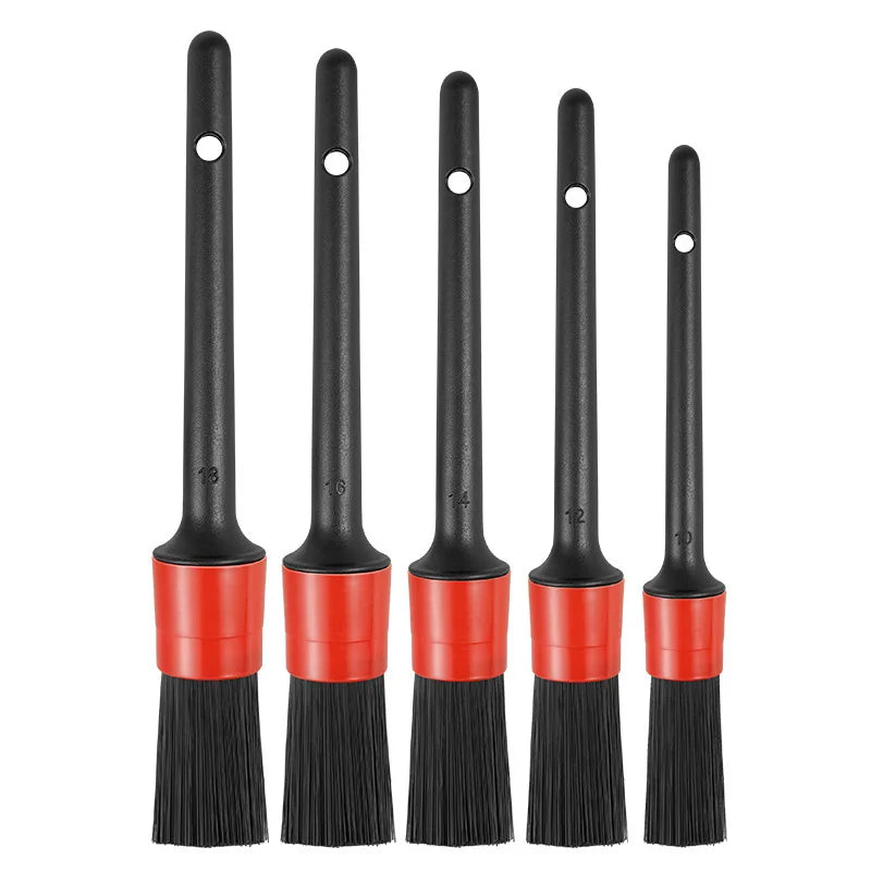 A set of black car detailing brushes with red handles and soft bristles.