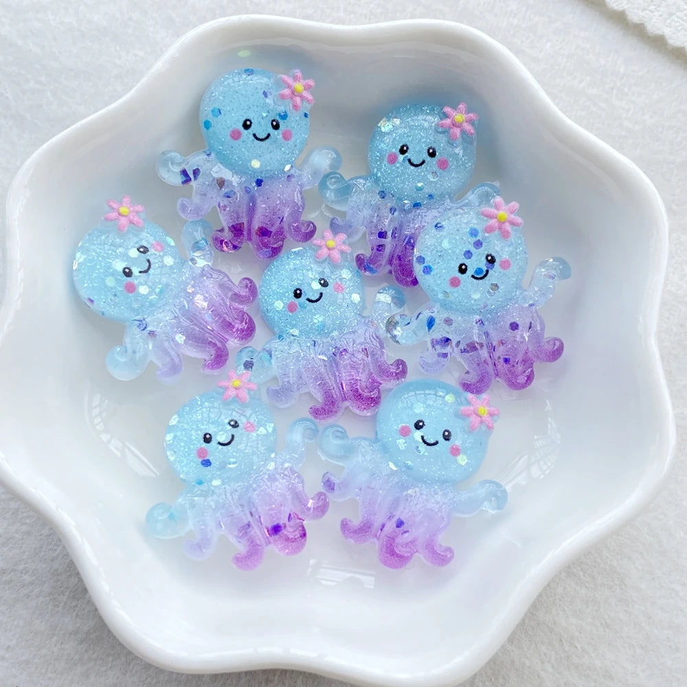 A collection of translucent blue and purple resin charms shaped like sea creatures for crafting and jewelry making