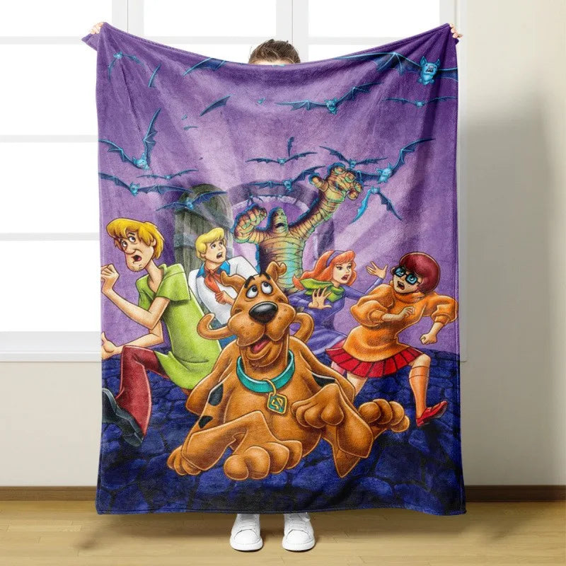 Lila Flanell-Überwurf mit Cartoon-Illustrationen von Scooby-Doo und anderen Charakteren.