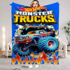 A colorful flannel throw blanket featuring a cartoon depiction of a monster truck.