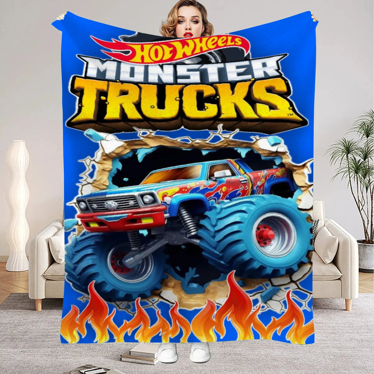 A colorful flannel throw blanket featuring a cartoon depiction of a monster truck.
