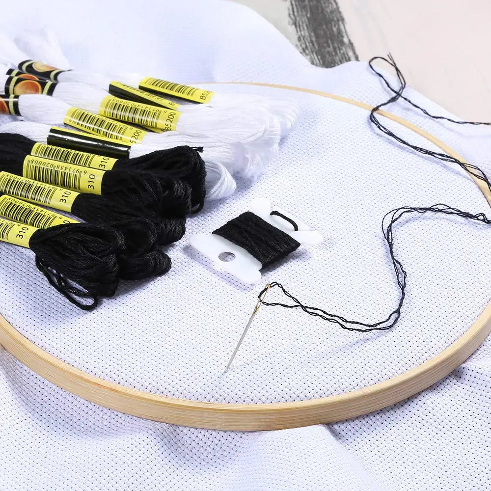 A set of 24 embroidery floss in white and black colors is displayed on a white surface.