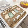 A wooden tray featuring vintage laundry items like soap bottles, fabric squares, and a clock, used as a top cover for a washe