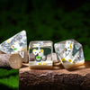 A set of clear resin dice shaped like adorable animals, including a bear and a rabbit, resting on a wooden surface.
