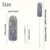 A gray telescopic duster with a fluffy fiber head shown next to a ruler for size reference.