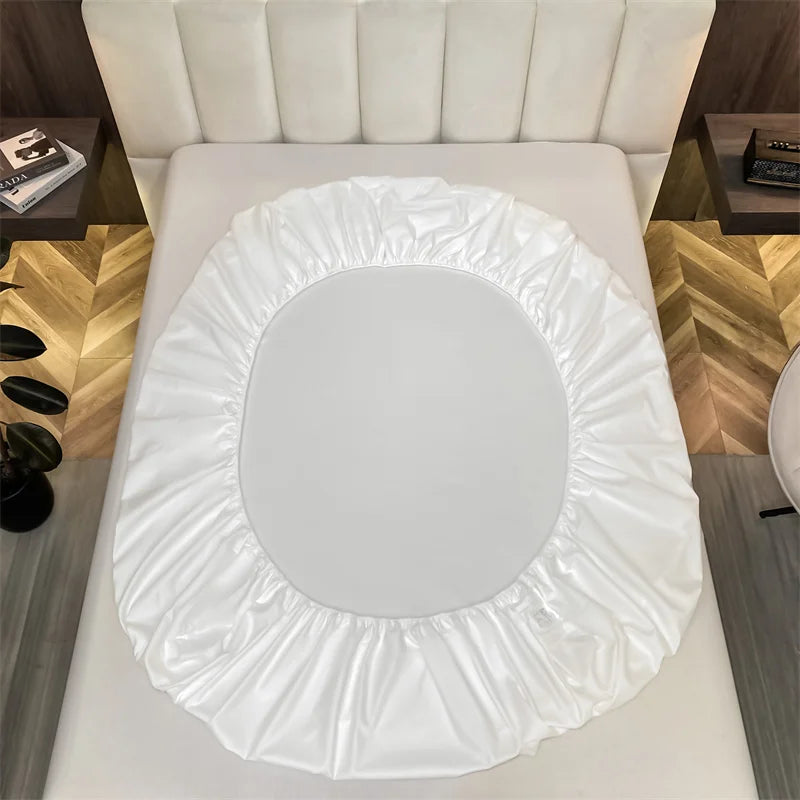 Juego de sábanas ajustadas de algodón blanco de lujo exhibido en una cama.