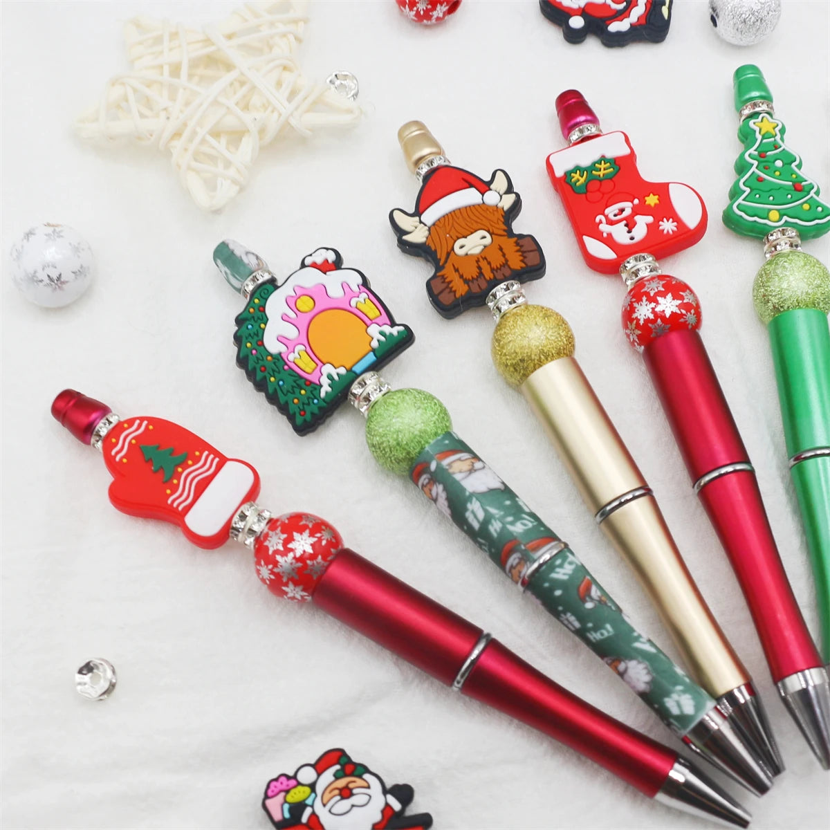 A collection of DIY beaded ballpoint pens featuring various Christmas-themed beads and designs.