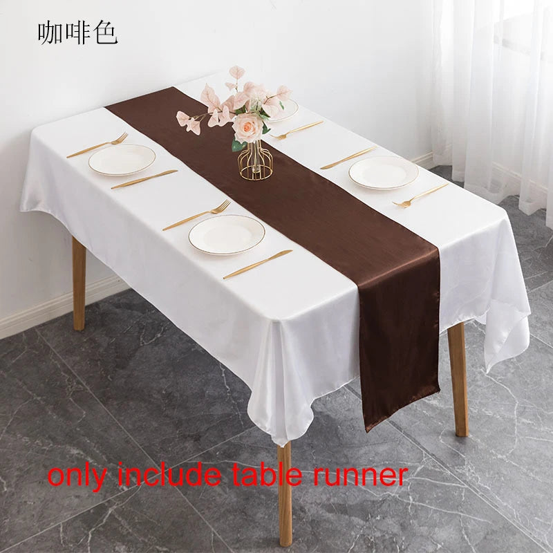 Elegant brown satin table runner set for events featuring white plates and floral accents