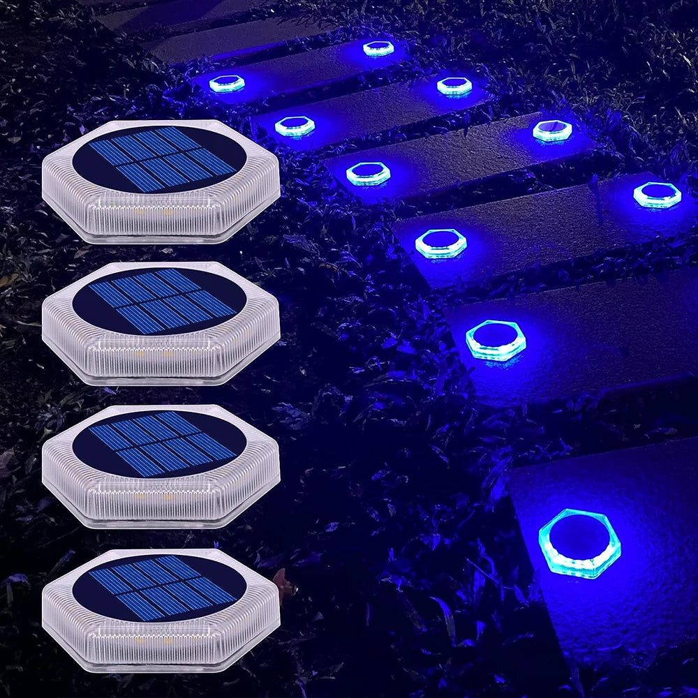 A series of solar powered LED step and path lights illuminating a dark, wet surface.