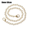 A string of small, round white pearls on a gold-toned chain strap.