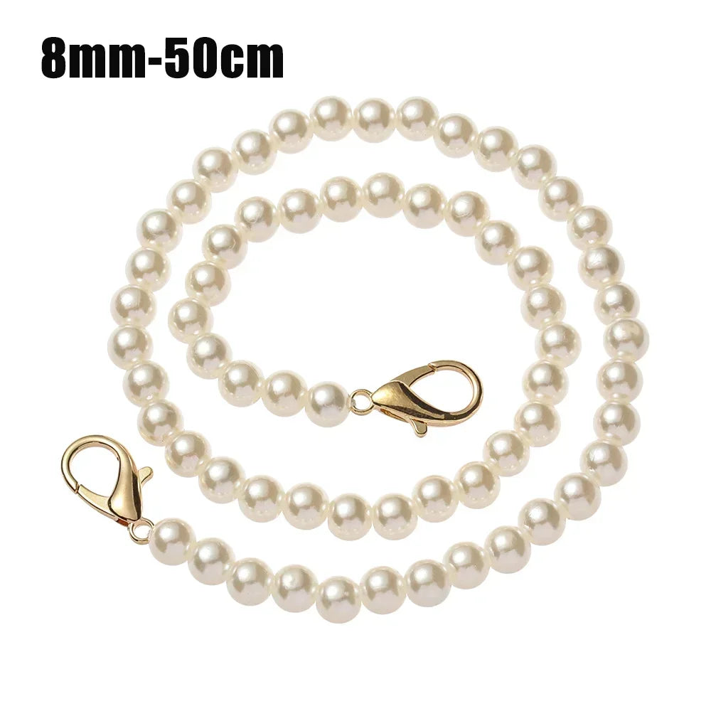 A string of small, round white pearls on a gold-toned chain strap.
