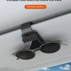 A pair of sunglasses is displayed on a magnetic holder mounted on a car window frame.